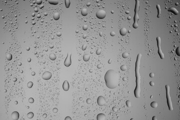 Water drops on grey glass surface, closeup