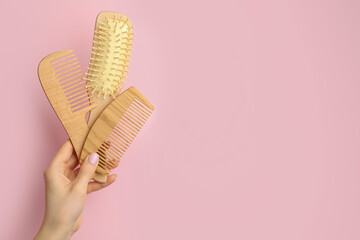 Woman with wooden brush and combs on pink background, closeup. Space for text
