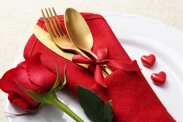 Romantic place setting with red rose on white table, closeup. Valentine's day celebration