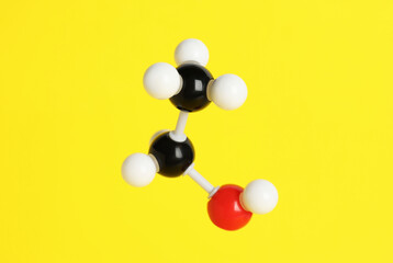 Molecule of ethanol on yellow background. Chemical model