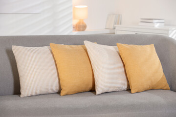 Soft decorative pillows on sofa in room
