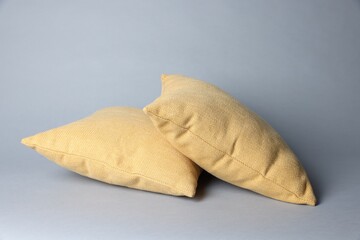 Two soft decorative pillows on grey background