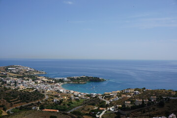 Panoramic view of Agia Pelagia in Crete, Greece from above with the blue sea and the clear blue sky in the background - Holiday homes, villas and hotels with swimming pools amidst beautiful vegetation