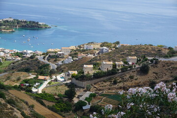 Obraz premium Panoramic view of Agia Pelagia in Crete, Greece from above with the blue sea and the clear blue sky in the background - Holiday homes, villas and hotels with swimming pools amidst beautiful vegetation