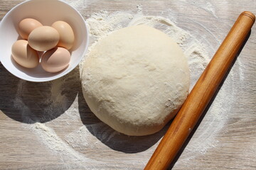 dough flour rolling pin and eggs