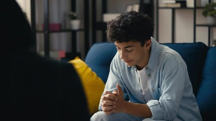 Sad teen boy sharing life struggles with a psychologist during a therapy session