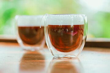 Red tea or called “ Dragon blood tea ” in the small clear glass
