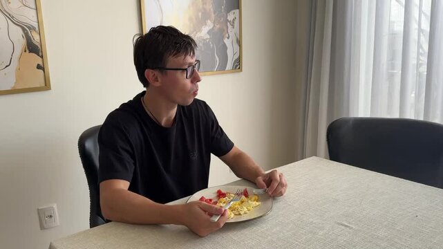 homem comendo ovos e tomate no almo&ccedil;o 
