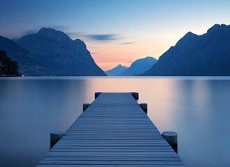 Fototapeta premium Wooden Pier Leading to Calm Lake with Mountain Views at Sunset