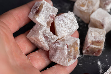 sweet Turkish delight slices with cherry slices on a black slate board