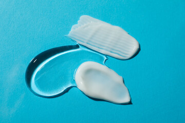 Body cream and gel on light blue background, flat lay