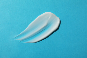 Body cream on light blue background, top view
