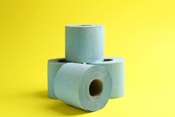 Light blue toilet paper rolls on yellow background