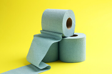 Light blue toilet paper rolls on yellow background