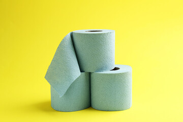 Light blue toilet paper rolls on yellow background