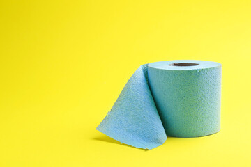 Light blue toilet paper roll on yellow background, space for text
