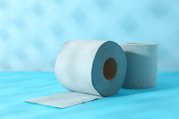 Light blue toilet paper rolls on color background, closeup