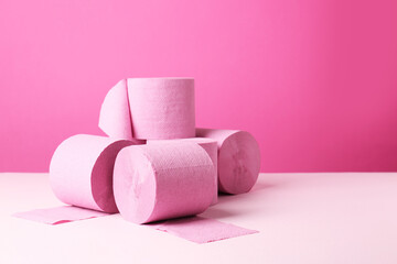 Color toilet paper rolls on pink background. Space for text