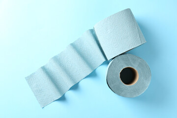 Color toilet paper rolls on light blue background, top view