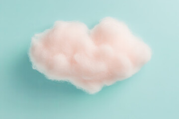 Fluffy pink cotton cloud on light blue background, creating whimsical and dreamy atmosphere. Perfect for creative projects or children themes
