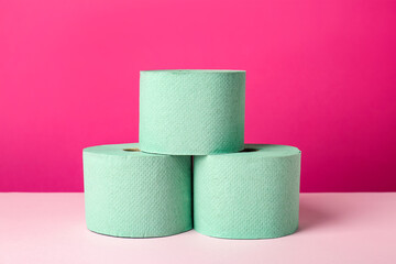 Green toilet paper rolls on pink background