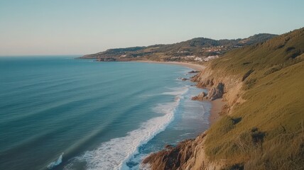 Obraz premium Tranquil Coastal Scene: Aerial View of Sandy Beach and Rolling Green Hills