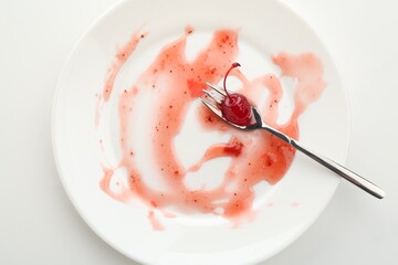 Dirty plate and fork on white background, top view