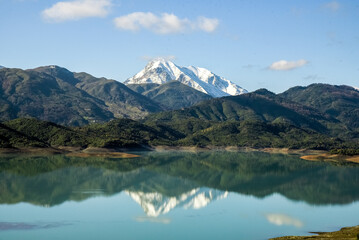 Beautiful landscape of lake and reflection of blue sky, clouds and mountains on surface of lake, Panoramic view of lake and snow-covered mountain and Forest trees calm in Jijel Algeria North African.