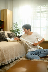 Young man is focused on assembling a table and follows the instruction manual in his living room