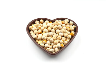 Roasted white chickpeas in wooden bowl on white background, top view. White chickpeas, with their high fiber content, are very healthy to consume.