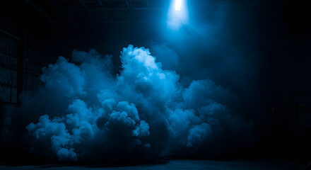 Dramatic blue smoke clouds illuminated by a single overhead light in a dark industrial setting