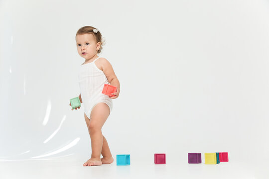 Cute little baby girl one year old and looking to the side, isolated white background.