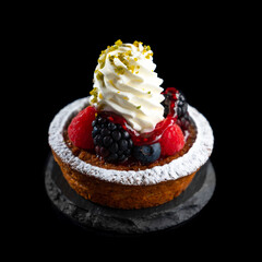 ラズベリーとブラックベリーとブルーベリーと生クリームをデコレーションしたミックスベリータルト　黒背景の切り抜き