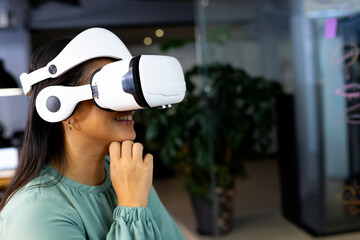 Woman using VR headset in modern office, exploring virtual reality technology, copy space