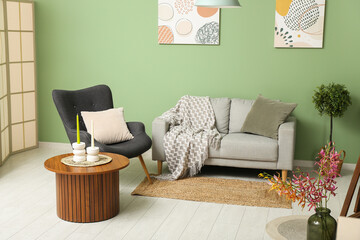 Modern living room interior with grey sofa, armchair and coffee table