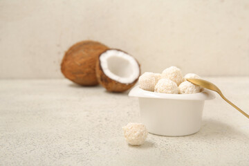 Delicious white chocolate candies with coconut topping on light table