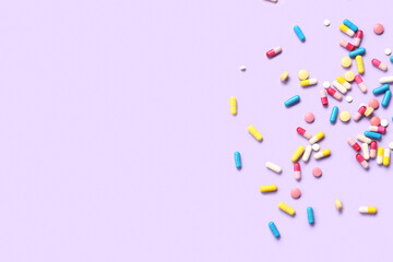 Many different pills on lilac background