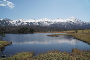 Snow-covered Shiretoko mountains and reflecting lake