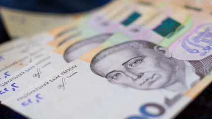 Ukrainian banknotes arranged in an artistic display, showcasing vibrant colors and intricate...