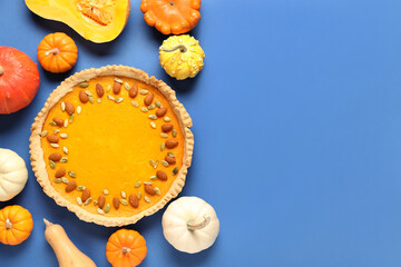 Tasty pumpkin tart with seeds and almond on blue background