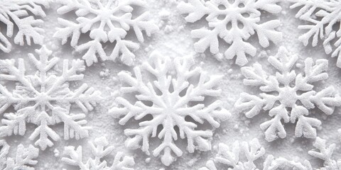 Several white decorative snowflakes are arranged on a white surface