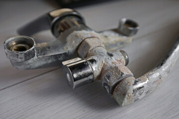 A rusty water faucet. Outdated plumbing. A broken faucet with lime coating.