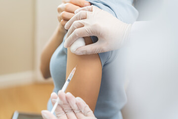 Health care, corona virus, hand of woman nurse, doctor giving syringe vaccine, injection dose on arm sick patient at clinic. Vaccination, immunization disease prevention against flu pandemic influenza © KMPZZZ