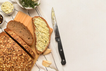 Wooden board of fresh bread with butter and different spices on white background