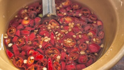 Fish sauce and chili in a brown ceramic bowl to add flavor to the food.