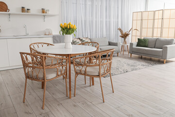 Vase with tulips on dining table in interior of modern kitchen
