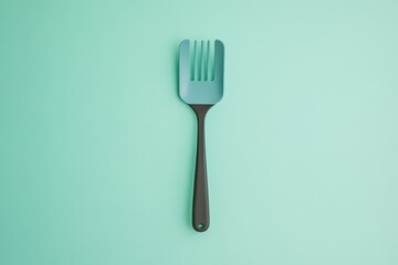 A blue and black slotted cooking utensil on a smooth surface