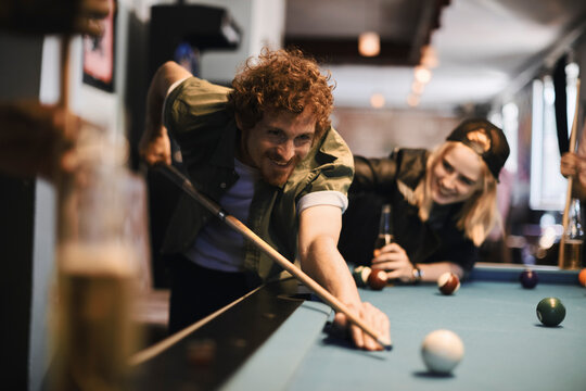 Young people playing pool in a club