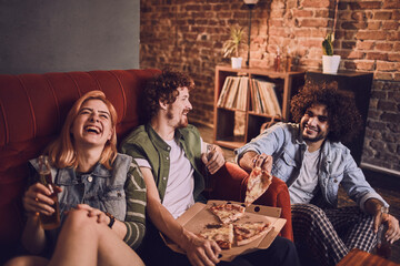 Young group of people having a house party with pizza and beer