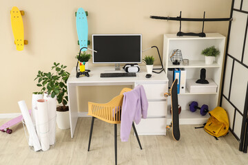 Interior of teenager's room with workplace, plants and skateboards